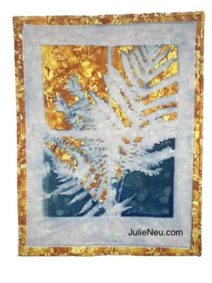 quilt of white fern leaves image in a window over orange background fabric